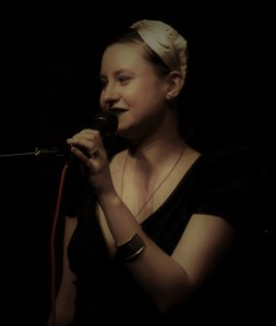 dark hue portrait of Maria Cohut speaking into a microphone